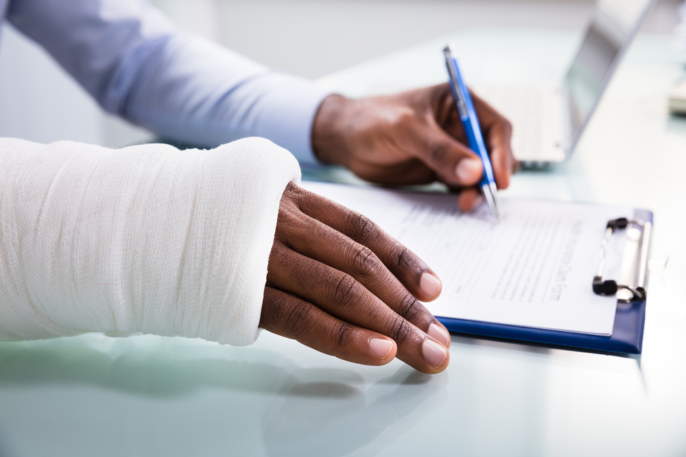 Will The Car Insurance Company Compensate Me? - Injured Man Filling Insurance Claim Form